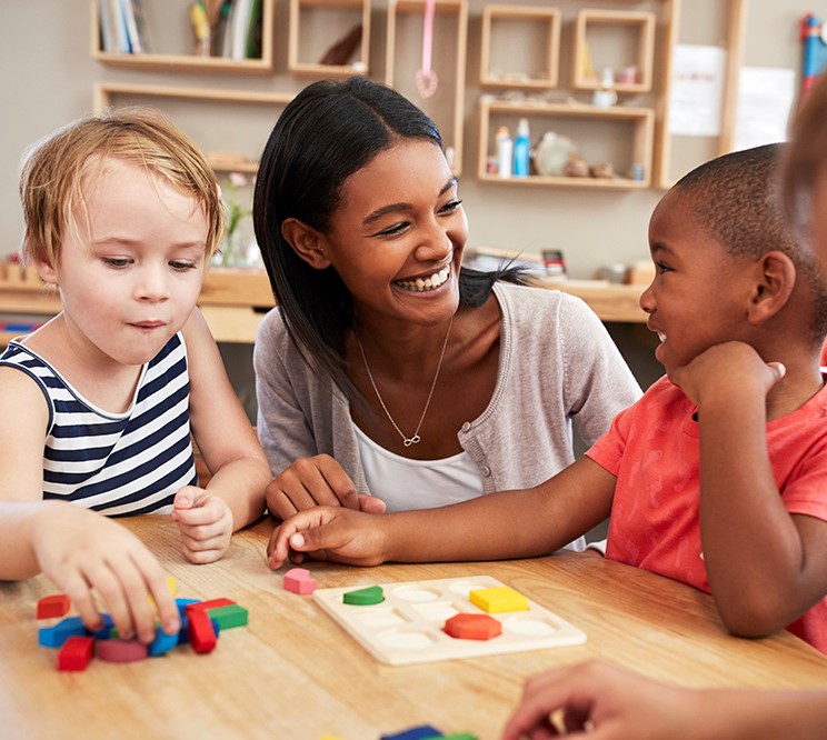 A woman sitting at the table with two children.