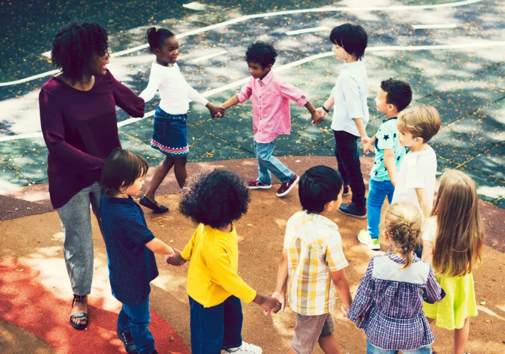 A group of children holding hands in front of the ocean